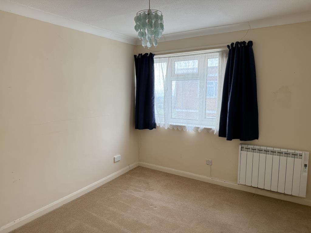 Lot: 126 - TWO-BEDROOM TOP FLOOR FLAT WITH UNINTERRUPTED SEA VIEWS - Bedroom two with fitted carpet and painted walls